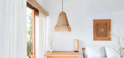Boho υπνοδωμάτιο με φωτιστικό από φυσικά υλικά, ξύλινη κονσόλα και διακοσμητικό τοίχου σε φωτεινό χώρο.