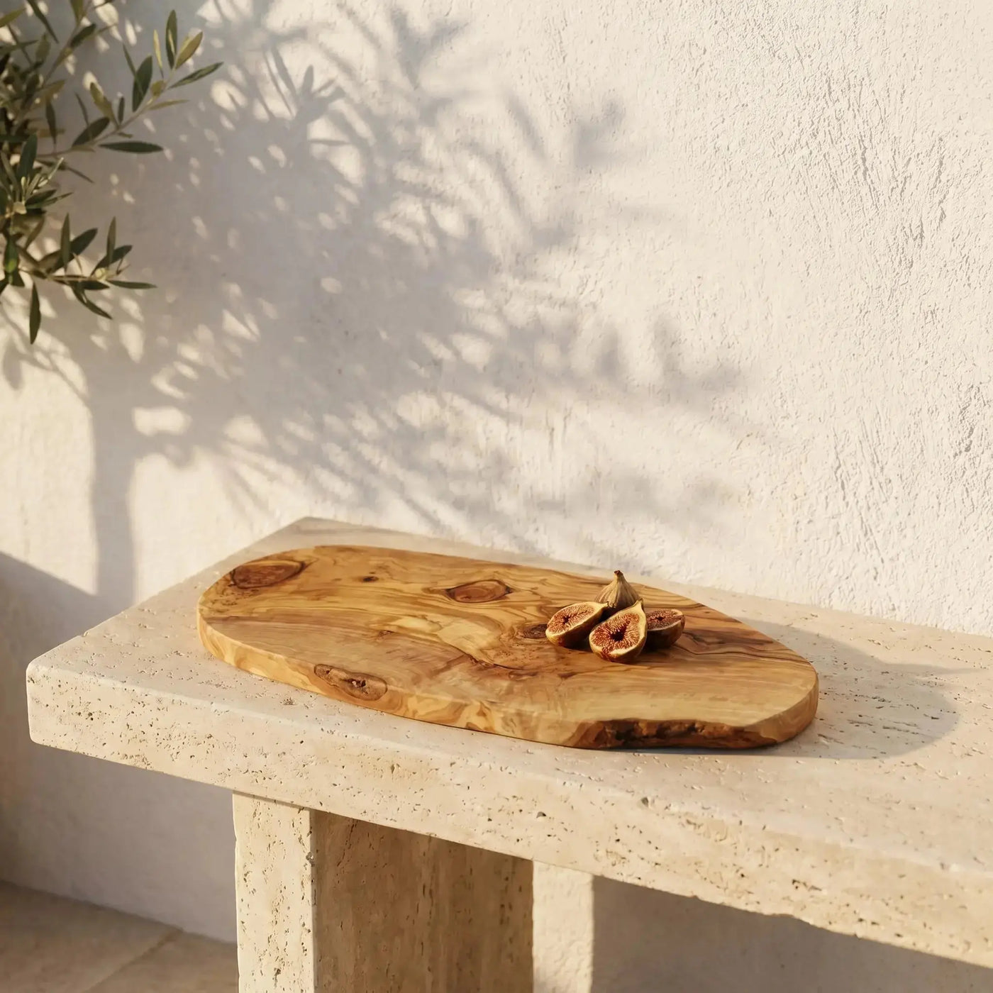 Πλατώ Rustic χειροποίητο από ξύλο ελιάς σε πέτρινη βεράντα με σκιές ελιάς και φρέσκα σύκα