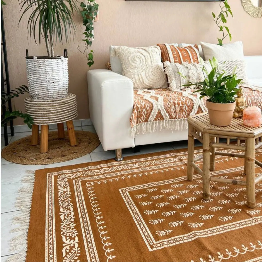 Το χαλί Zafran σε boho σαλόνι με λευκό καναπέ, τραπεζάκι μπαμπού και φυτά